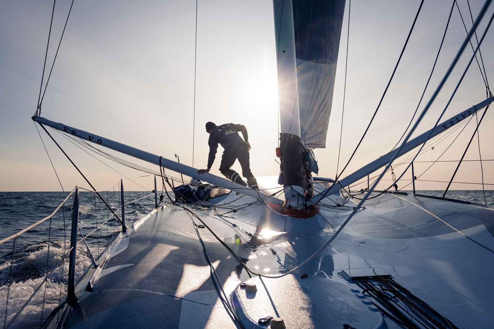Tripulação trabalhando na proa de um veleiro da The Ocean Race contra o sol